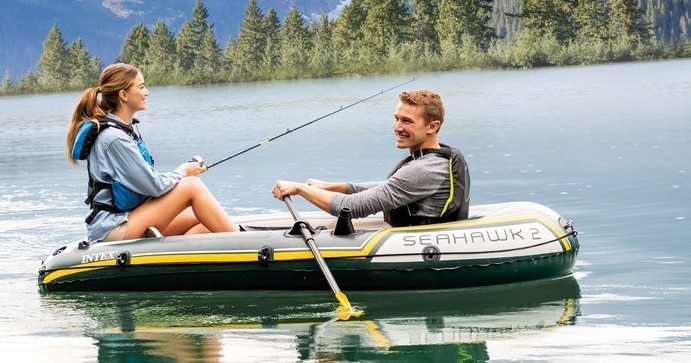two people sitting in an inflatable kayak